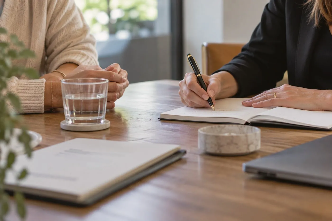 A lawyer taking notes during a meeting with a client